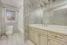 Full bath with vanity, light tile patterned floors, and shower / bath combo with shower curtain