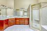 Full bathroom with a stall shower, double vanity, and light tile patterned floors