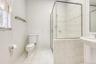 Full bathroom featuring light tile patterned floors and a shower stall