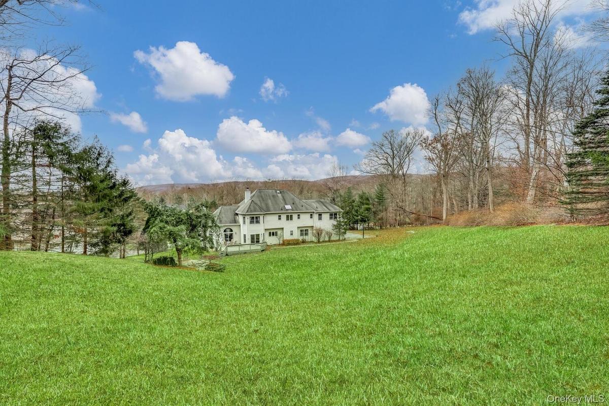 View of green lawn with a wooded view