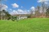 View of green lawn with a wooded view
