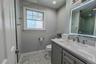 Stylishly renovated bathroom featuring a contemporary vanity, an illuminated LED mirror, beautiful teal accent tiling, and eye-catching patterned tile