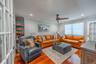 Bright, spacious living room with stunning hardwood floors, recessed lighting, and elegant French doors.