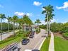 Grand gated entrance with 24-hour guard-gated security and lush tropical landscaping.