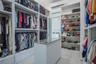 Large walk-in closet with custom built-ins and direct access to laundry.