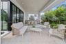 Outside living room with kitchen overlooks pool