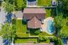 Expansive outdoor area featuring a covered pool, a paved patio surround, and a large grassy yard