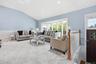 Living space featuring a vaulted ceiling with recessed lighting, light blue walls, and white wainscoting