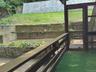 Covered porch off kitchen facing back yard with large deck below.