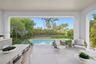 Outside living room with kitchen overlooks pool
