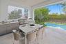Outside living room with kitchen overlooks pool