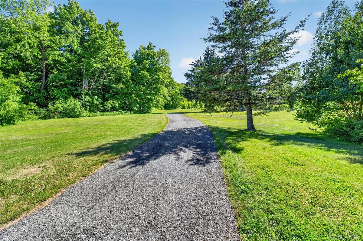 Approach the home via a picturesque driveway framed by meticulously maintained grounds.