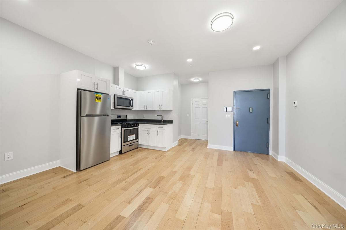 Open-concept room featuring wood-finish flooring, recessed lighting, and a modern kitchen