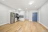 Open-concept room featuring wood-finish flooring, recessed lighting, and a modern kitchen