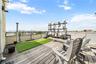 Rooftop deck featuring wood-finish flooring, a green artificial turf area, and a metal railing