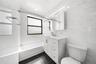Bathroom featuring white subway tile walls, a white vanity with brushed nickel hardware, a white bathtub, a recessed medicine cabinet with integrated 