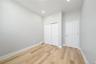 Light-colored wood-finish flooring complements the neutral wall color and white trim