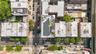 Aerial perspective of an urban neighborhood featuring street-level parking, established street trees, and a building with rooftop solar panels