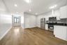 Open-concept living space featuring wood-finish flooring, recessed lighting, and a modern kitchen