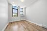 Room featuring wood-finish flooring, white baseboards, and light gray walls