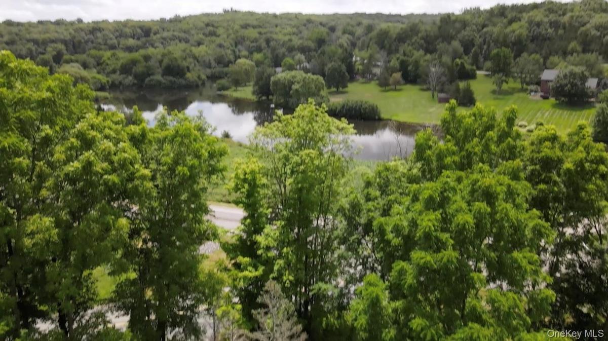 Aerial view of lot with a large pond across the road