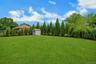 Virtually staged landscape rendering with proposed arborvitae privacy hedge along the rear fence.