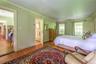 Bedroom with wood finished floors and ornamental molding