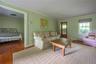 Living room featuring a baseboard heating unit, wood finished floors, and ornamental molding