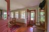 Foyer entrance with baseboard heating, crown molding, wood finished floors, and plenty of natural light