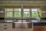 Kitchen with dishwasher, white cabinetry, and dark stone counters