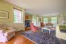 Living area with hardwood / wood-style flooring, baseboard heating, a fireplace, a baseboard heating unit, and a wainscoted wall