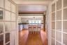 Dining room featuring light wood finished floors, french doors, and beam ceiling
