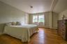 Bedroom featuring hardwood / wood-style floors, a baseboard heating unit, and vaulted ceiling
