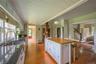 Kitchen featuring radiator, freestanding refrigerator, wood-type flooring, butcher block countertops, and a breakfast bar area
