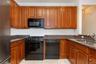 U-shaped kitchen with wood cabinetry and dark granite-style countertops