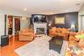 Spacious open living area with large windows for natural light features wood burning fireplace