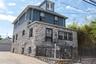 Stone and siding exterior with wrought iron railing, concrete stairs, and security bars