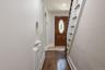 Hardwood flooring entry with a wooden front door featuring an oval leaded glass insert