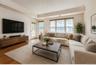 Spacious living area featuring wood-finish flooring, recessed lighting, and a tray ceiling with crown molding