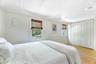 Primary bedroom with dual closets and backyard views.