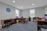 Home office with dark carpet and recessed lighting
