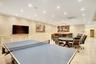Rec room featuring recessed lighting, a wainscoted wall, ornamental molding, and a decorative wall