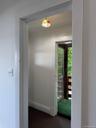 Delightful mud room between kitchen & back porch featuring cathedral ceiling & window facing sunporch.