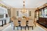 Dining area featuring ornamental molding, a chandelier, light colored carpet, and stairway