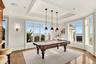 Recreation room featuring a tray ceiling, ornamental molding, billiards, and a water view