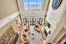 Living room featuring plenty of natural light, a water view, a decorative wall, and a high ceiling