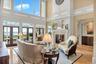 Living room featuring a water view, a towering ceiling, french doors, and a premium fireplace