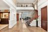 Bright 2 story entry foyer with a decorative wall, stairs, a high ceiling, crown molding, and ornate columns
