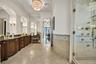 Full bathroom with vanity, a shower stall, crown molding, tile walls, and a wainscoted wall