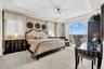 Bedroom featuring multiple windows, light colored carpet, a tray ceiling, access to exterior, and crown molding
